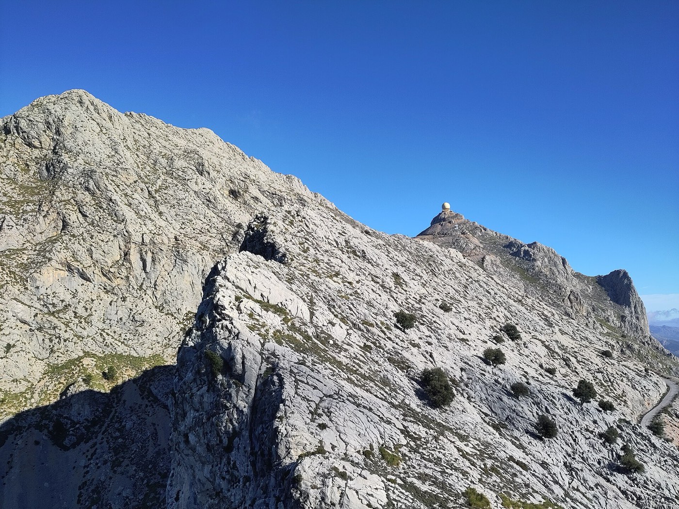 The radar dome of Puig Major just peeking over a rocky foreground ridge of the Serra de Son Torrella