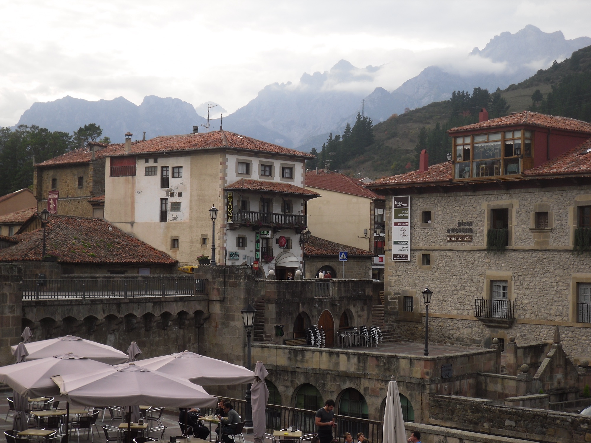 The town of Potes with the peaks of the Picos de Europa rising steeply behind its rooftops