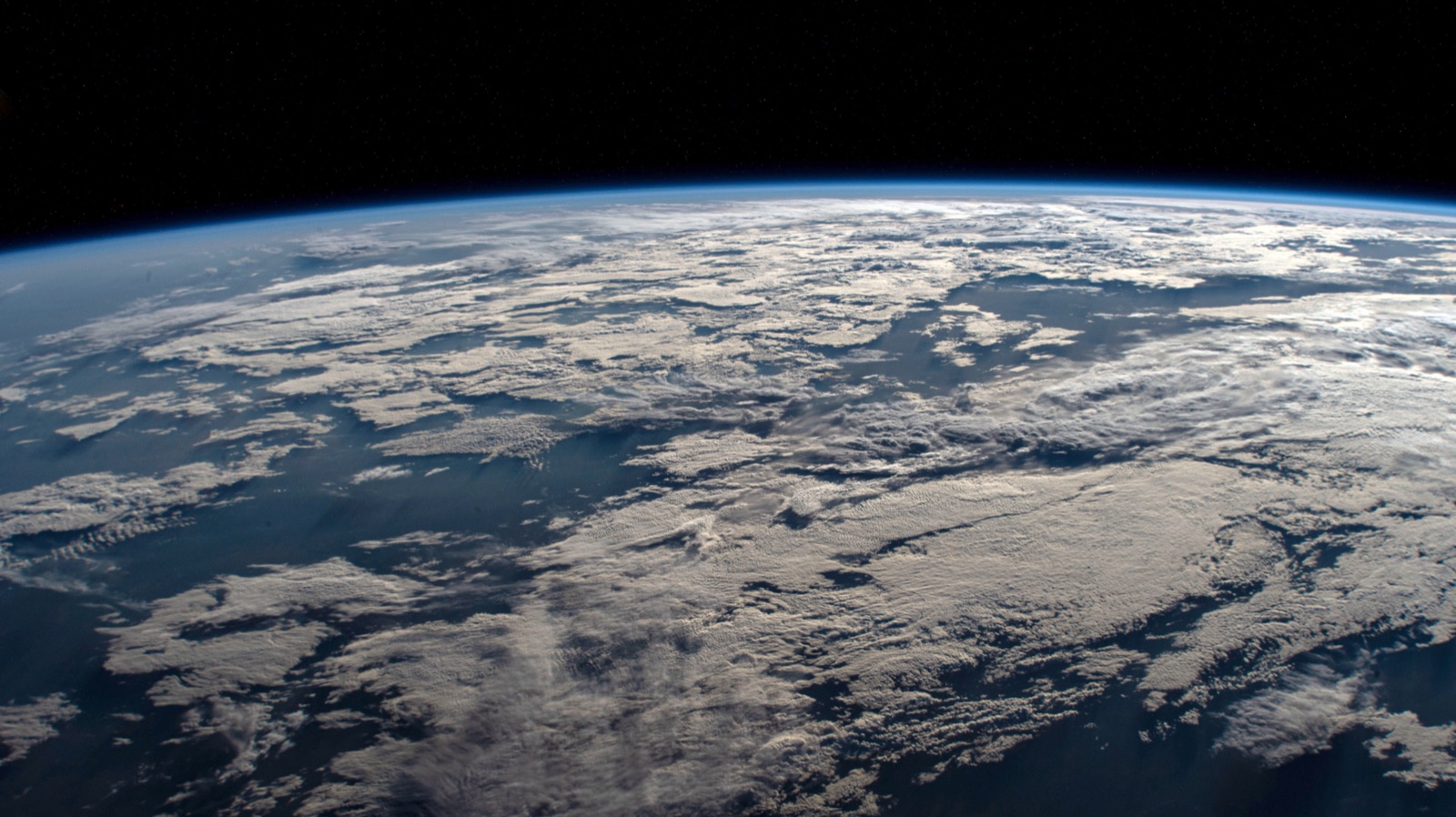 Earth's limb — the curved horizon — photographed from the International Space Station above a cloud-covered Western Australia
