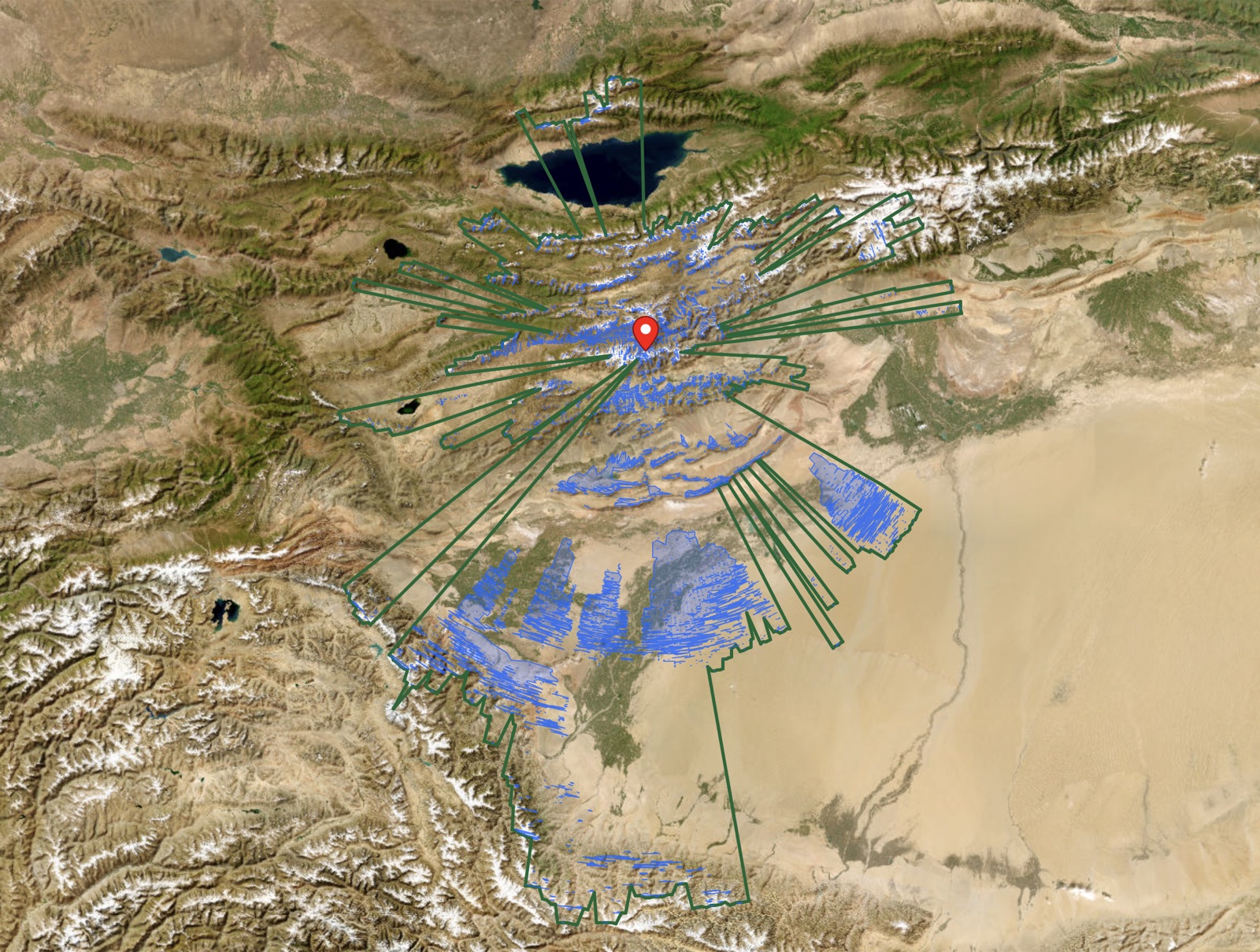 Satellite view across the sightline: Issyk-Kul's blue waters near the Tian Shan, then the corridors threading nearly 500 km across the Tarim Basin desert to snow-capped ranges beyond