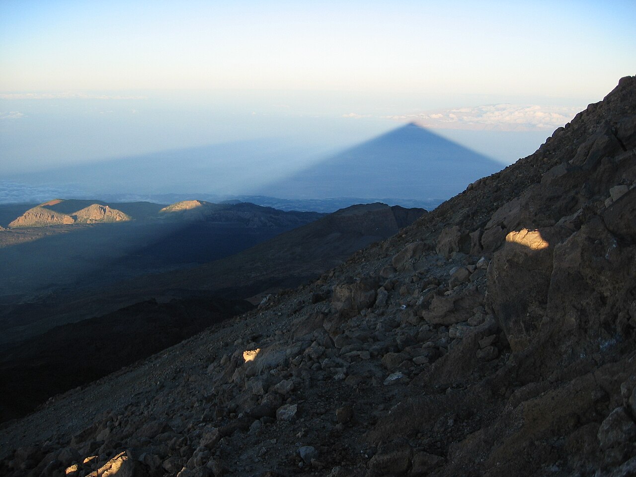 The triangular shadow of Teide at dawn, seen from near the summit, stretching over the Atlantic toward La Gomera