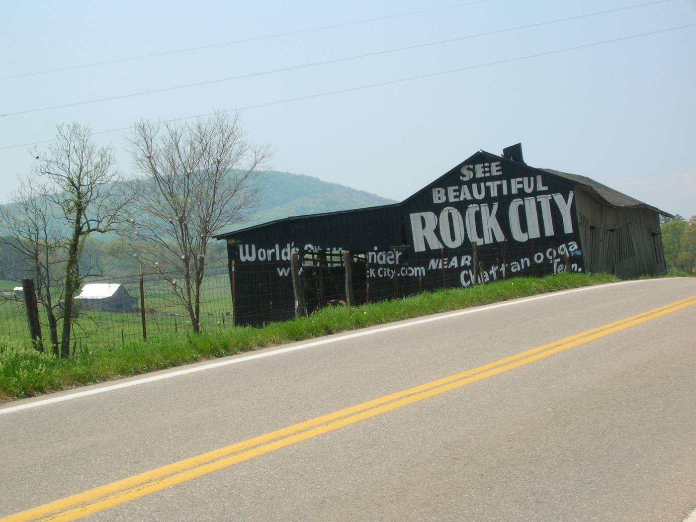 A barn with "SEE ROCK CITY" painted in large white letters across its black roof, part of the early-20th-century highway advertising campaign