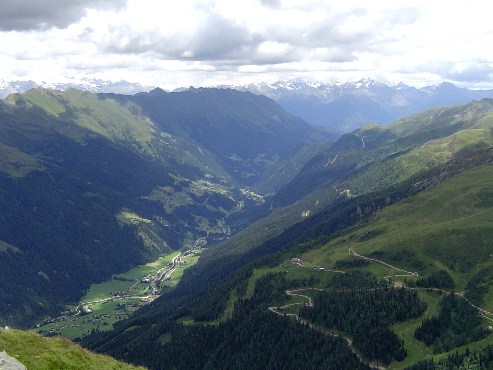 The Defereggental in East Tyrol seen down its axis from above: a deep, narrow V-shaped trench with villages strung along its green floor and high walls on both sides