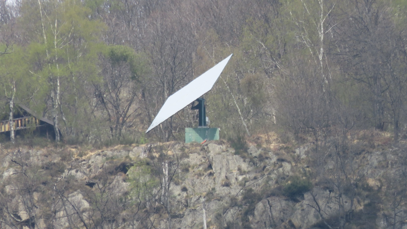 The steel sun mirror of Viganella on its mount on the wooded mountainside above the village